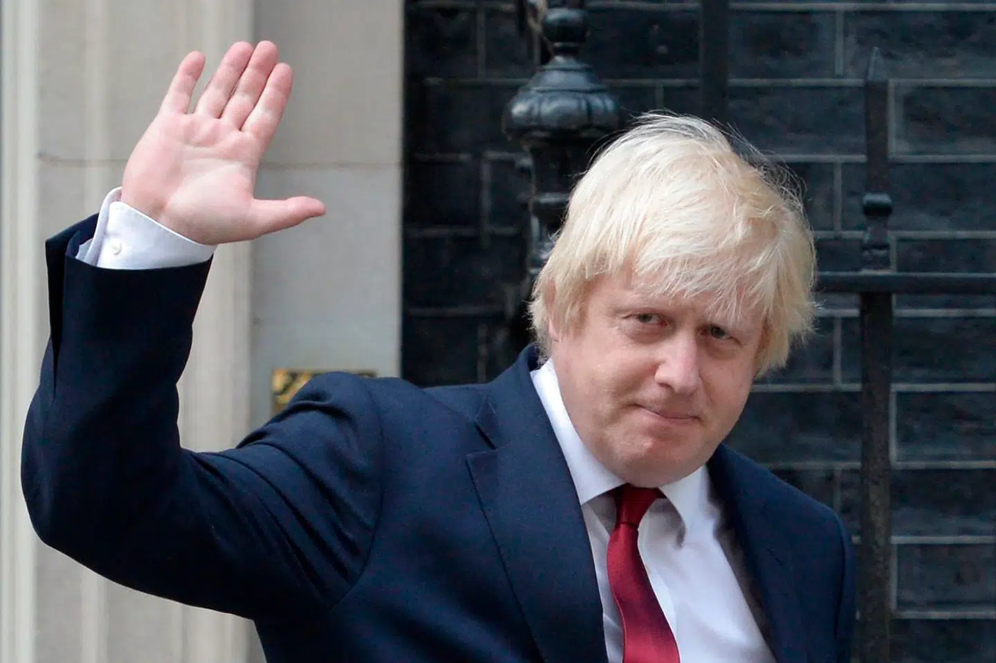 Newly appointed Foreign Secretary Boris Johnson waves as he leaves 10 Downing Street in central London on July 13, 2016 after new British Prime Minister Theresa May took office. Theresa May took office as Britain's second female prime minister on July 13 charged with guiding the UK out of the European Union after a deeply devisive referendum campaign ended with Britain voting to leave and David Cameron resigning. / AFP PHOTO / OLI SCARFF