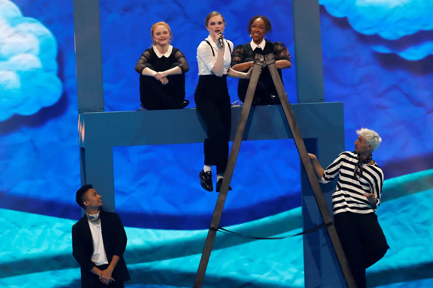 Leonora starter på scenegulvet, man skal i løbet af sangen op på stolen til sine korsangere.