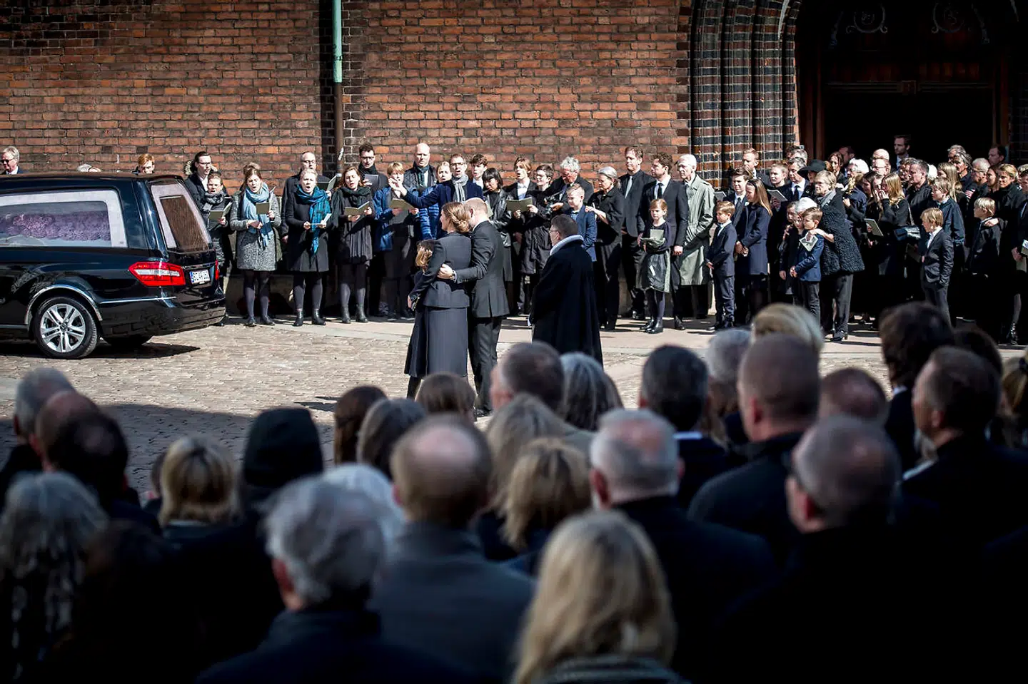 Anne Storm Pedersen og Anders Holch Povlsen med datter lytter til sang og kigger mod kisterne foran kirken efter begravelsen fra Aarhus Domkirke lørdag den 4. maj 2019 af de tre danske ofre for terrorangrebet i Sri Lanka. De tre omkomne var børn af Anne Storm Pedersen og Anders Holch Povlsen.
