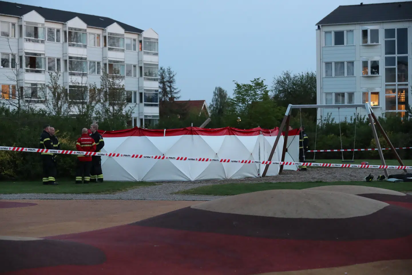 Politiet har afspærret store dele af området rundt om legepladsen, hvor en kvinde mistede livet lørdag aften.