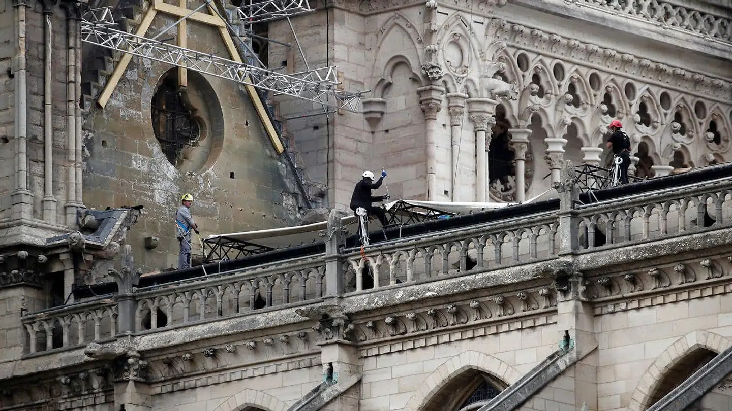 Her ses bjergbestigere ifærd med at få presenningen over Notre Dame.