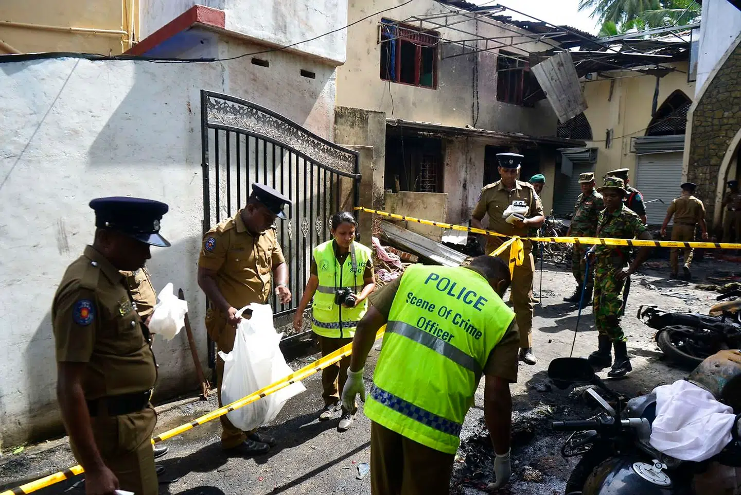 Sri Lankan security personnel and police investigators look through debris outside Zion Church following an explosion in Batticaloa in eastern Sri Lanka on April 21, 2019. - A series of eight devastating bomb blasts ripped through high-end hotels and churches holding Easter services in Sri Lanka on April 21, killing nearly 160 people, including dozens of foreigners. (Photo by LAKRUWAN WANNIARACHCHI / AFP)