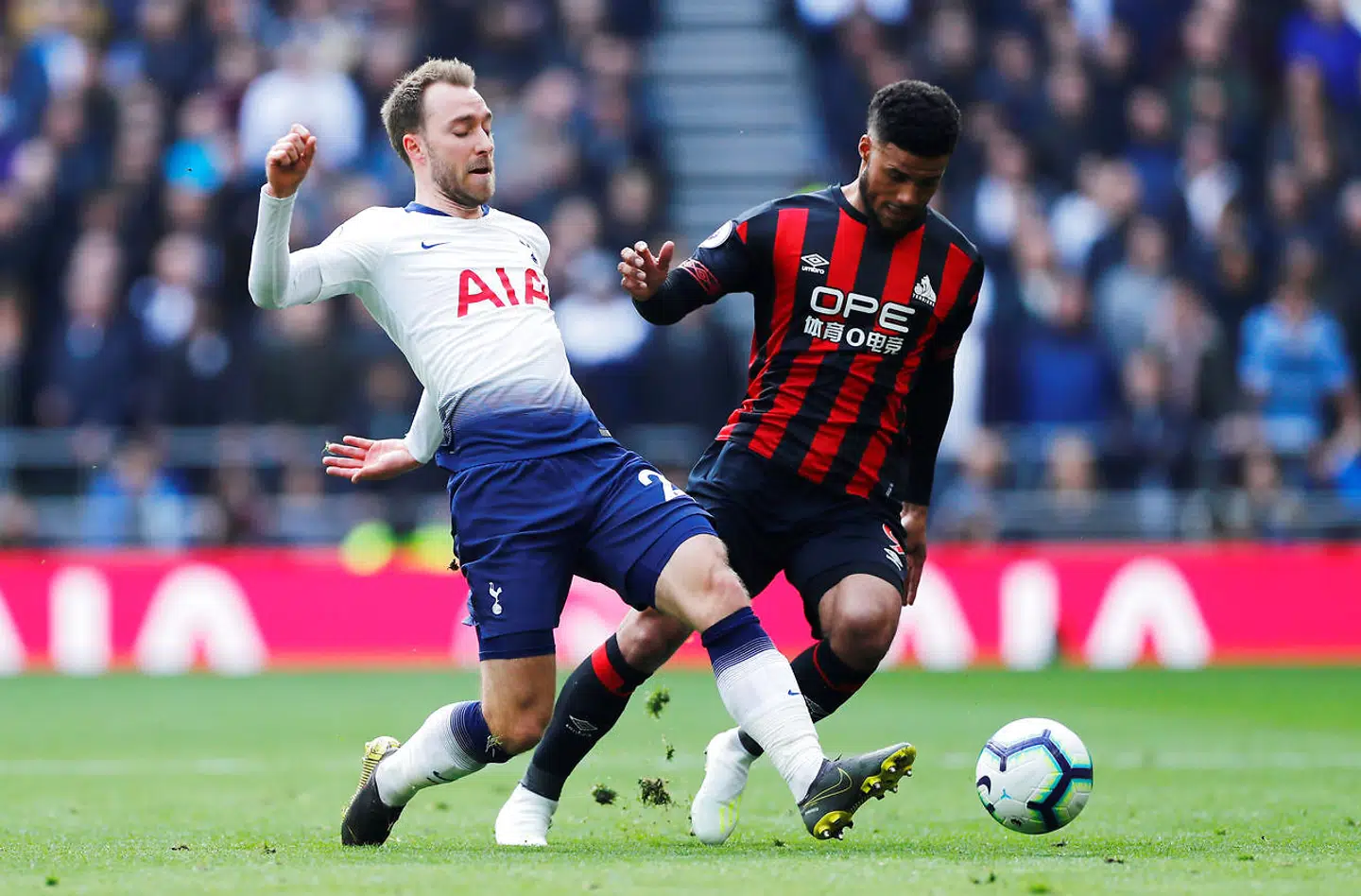 Tottenhams Christian Eriksen i duel med Huddersfield Town's Elias Kachunga.