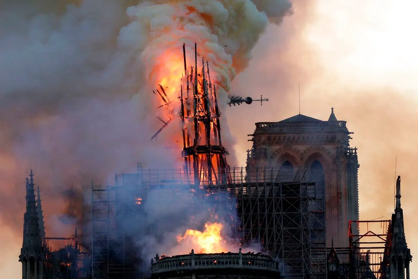 The steeple collapses as smoke and flames engulf the Notre-Dame Cathedral in Paris on April 15, 2019. - A huge fire swept through the roof of the famed Notre-Dame Cathedral in central Paris on April 15, 2019, sending flames and huge clouds of grey smoke billowing into the sky. The flames and smoke plumed from the spire and roof of the gothic cathedral, visited by millions of people a year. A spokesman for the cathedral told AFP that the wooden structure supporting the roof was being gutted by the blaze. (Photo by Geoffroy VAN DER HASSELT / AFP)