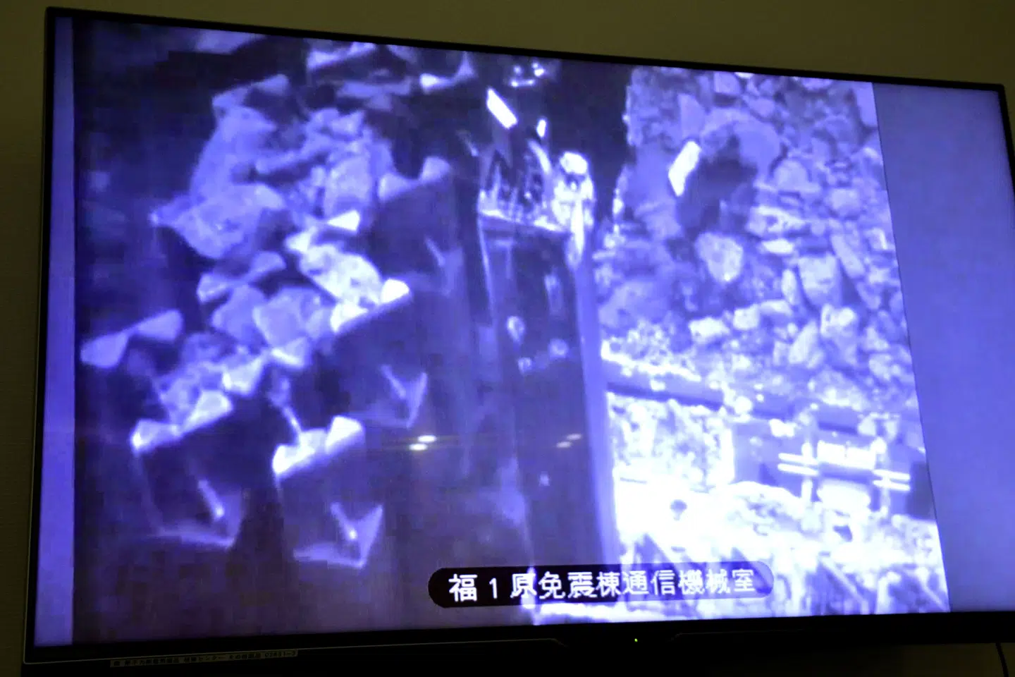 På en skærm ses oprydningsarbejdet i reaktorbygning nummer tre ved atomkraftværket Fukushima i byen Okuma. Kyodo/Reuters