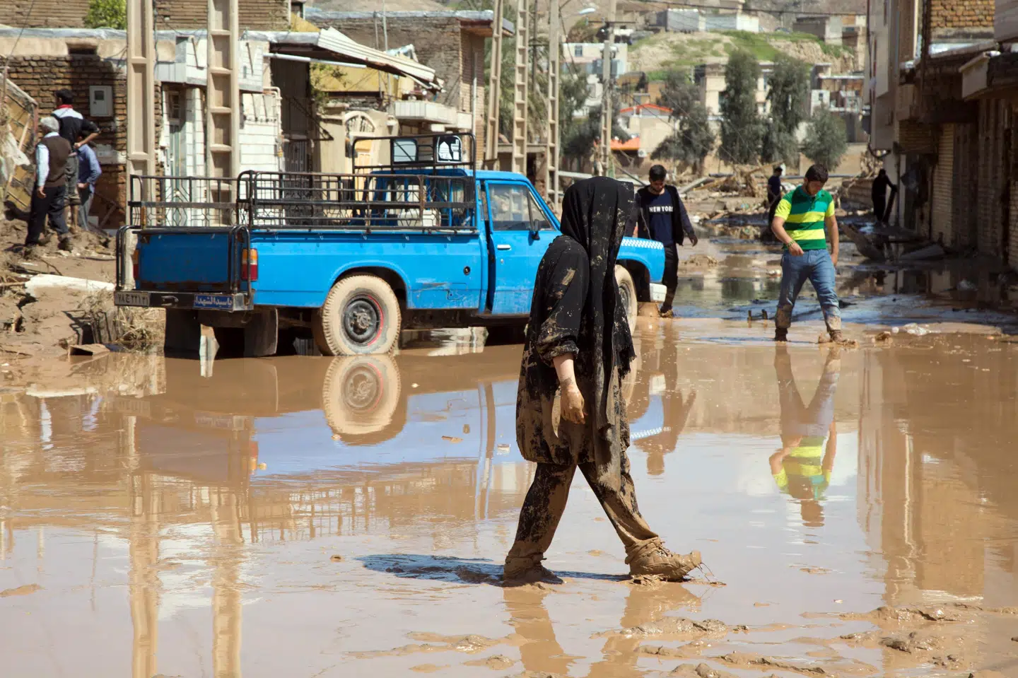 En iransk kvinde går gennem en oversvømmet gade i byen Poldokhtar i Lorestan-provinsen 2. april. Aziz Babanejad/Ritzau Scanpix