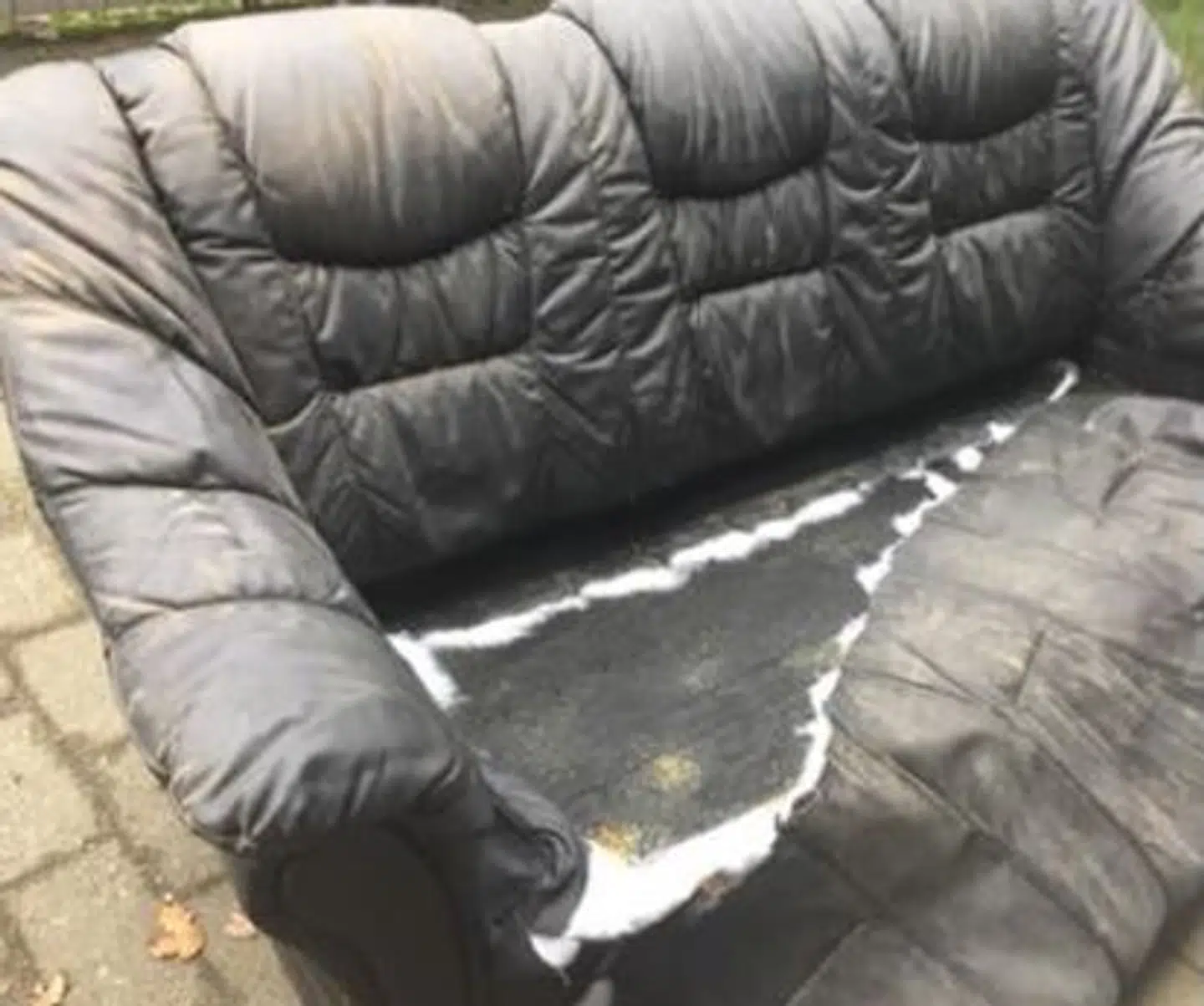 En ødelagt og usælgelig sofa lagt foran Frelsens Hær i Esbjerg uden for åbningstid.