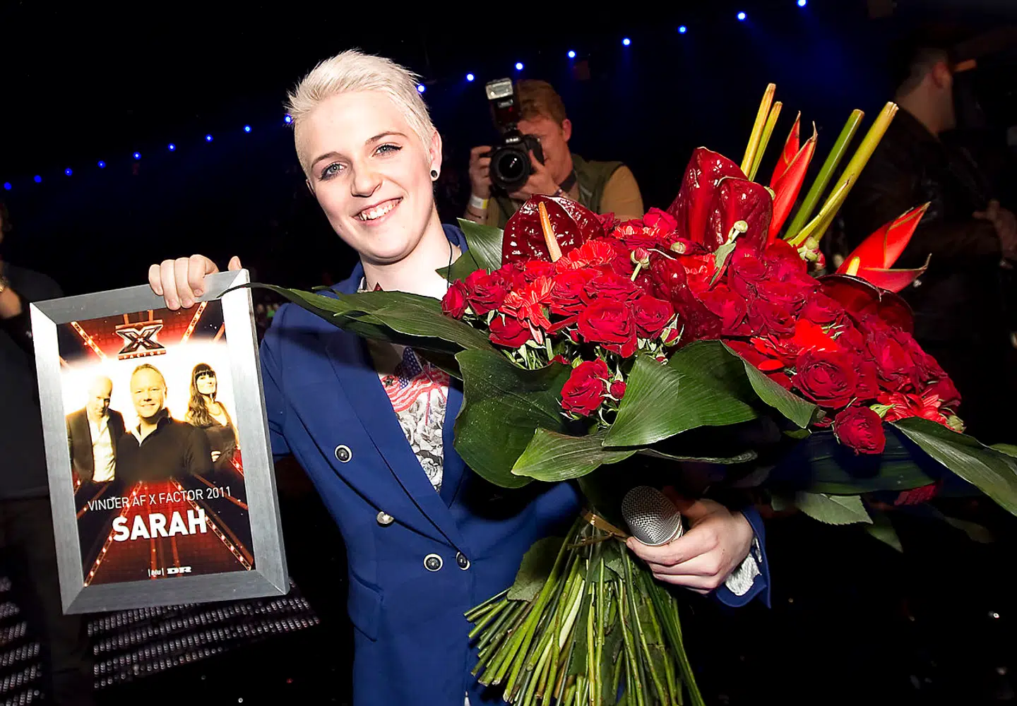 En glad vinder på scenen med blomster.