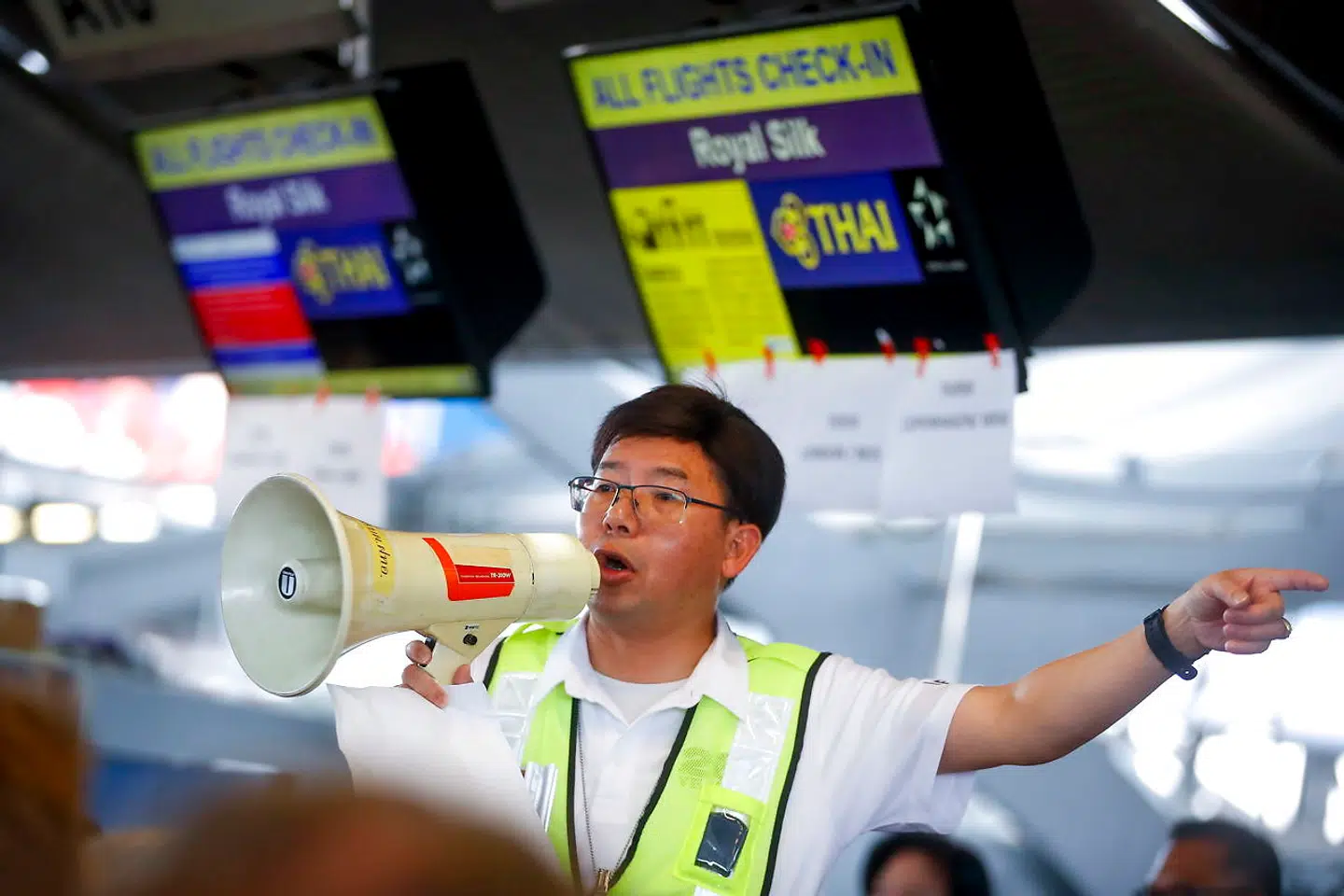 En medarbejder fra Thai Airways orienterer de mange passagerer om situationen.