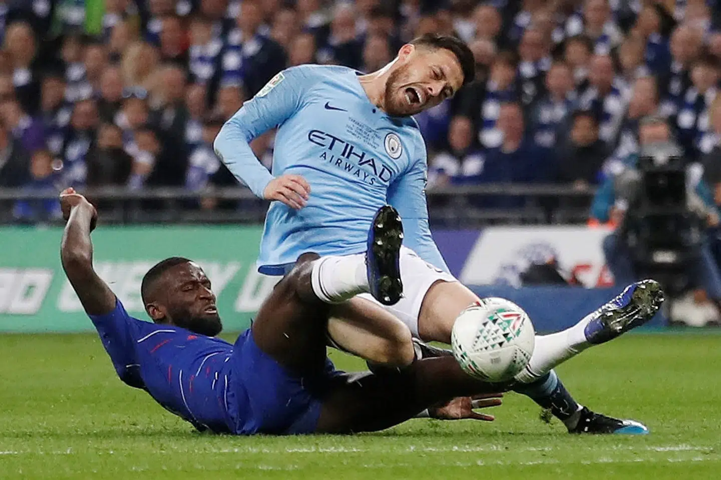 Der var masse af hårde dueller og tacklinger i søndagens Liga Cup-finale. Her er det Chelseas Antonio Rüdiger, som nedlægger Manchester Citys David Silva. Carl Recine/Ritzau Scanpix