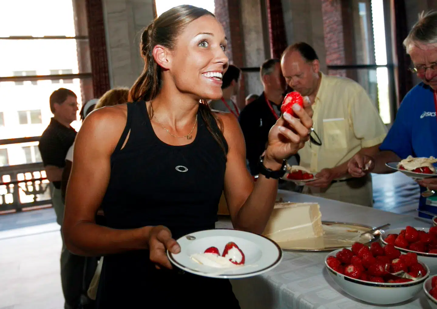 Athlete Lolo Jones of the US enjoys a juicy strawberry on June 5, 2008 at the traditional strawberry party prior to the Golden League Bislett Games. Jones will compete in the 100m hurdles event at the athletics meeting which will take place at Bislett Stadium in OslO on June 6. AFP PHOTO/SCANPIX/Heiko Junge. HEIKO JUNGE / SCANPIX NORWAY / AFP