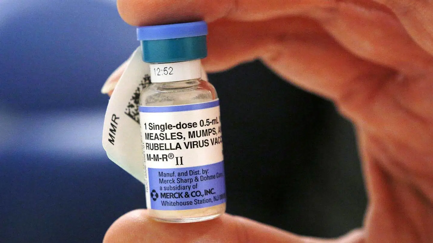 En sygeplejerske holder et glas med MFR-vaccine - mæslinger, fåresyge og røde hunde.