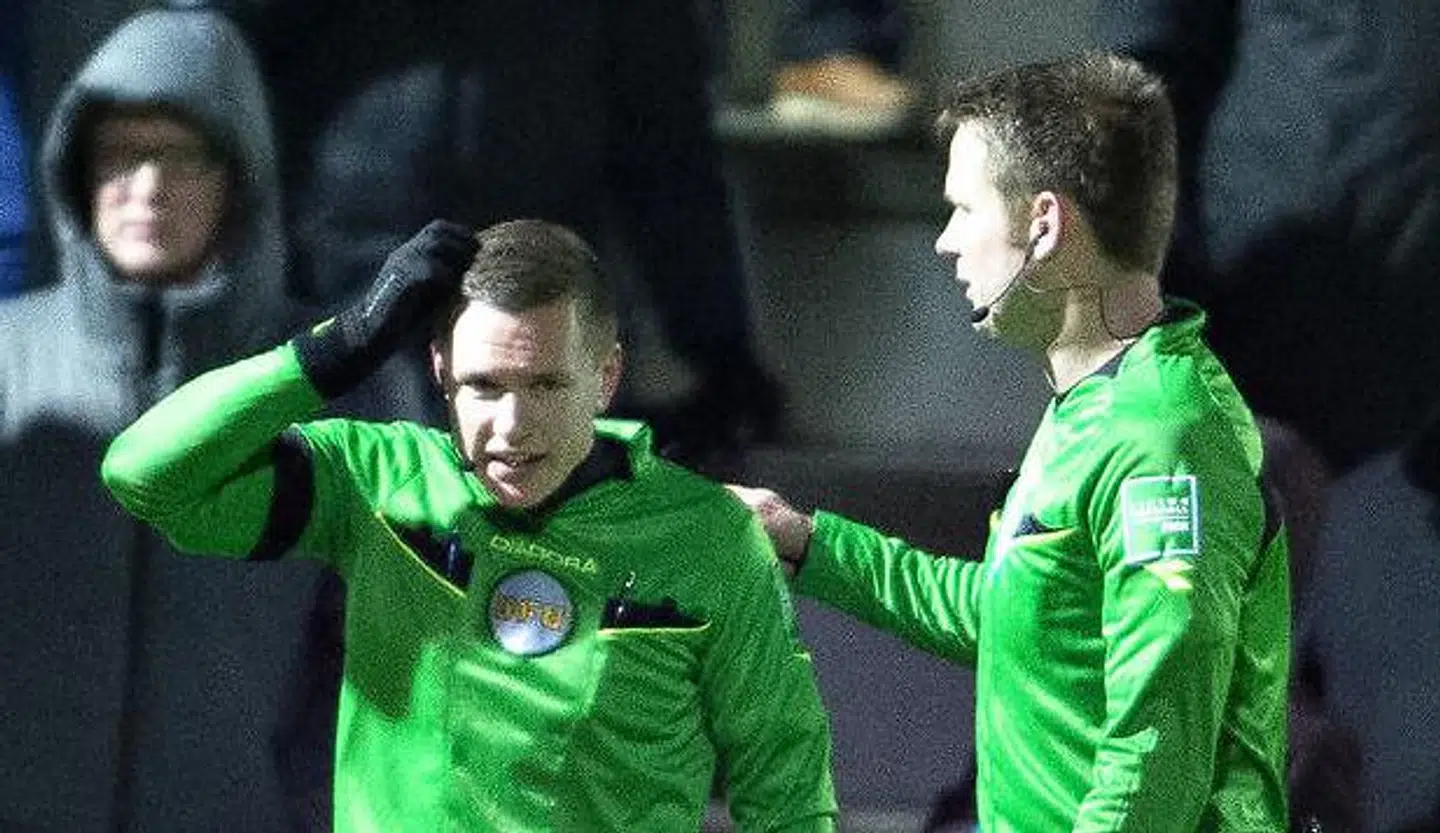 Liniedommer Henrik Hansen (tv) forklarer dommer Jens Maae, at han er blevet ramt af kasteskyts undervejs i mandag aftens Superliga-kamp i Hjørring mellem Vendsyssel FF og FC Midtjylland.