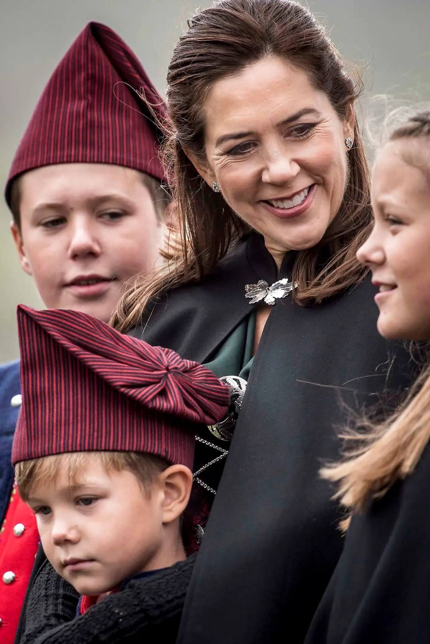 Prins Vincent krøb i sikkerhed under mors kåbe, da familien besøgte de syngende børn ved Osalund ved det officielle besøg på Færøerne, fredag den 24. august 2018. (Foto: Mads Claus Rasmussen/Ritzau Scanpix)