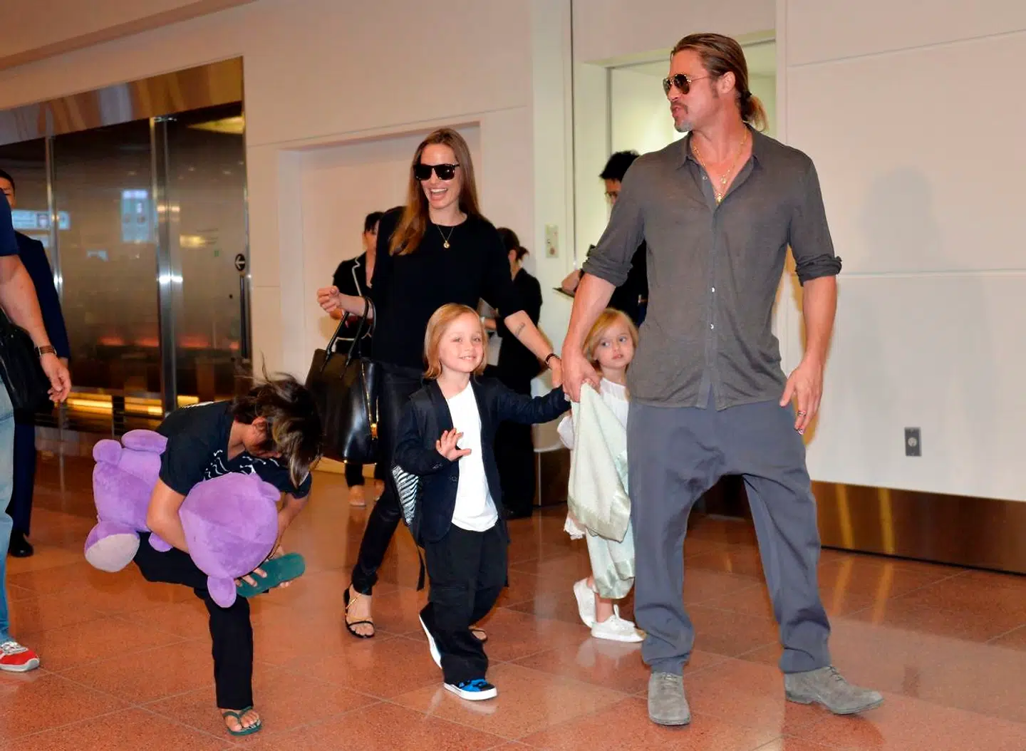 En familie, der holder sammen, rejser sammen. Her ses Brad Pitt og Angelina Jolie og deres voksende børneflok i lufthavnen i Tokyo i 2013.