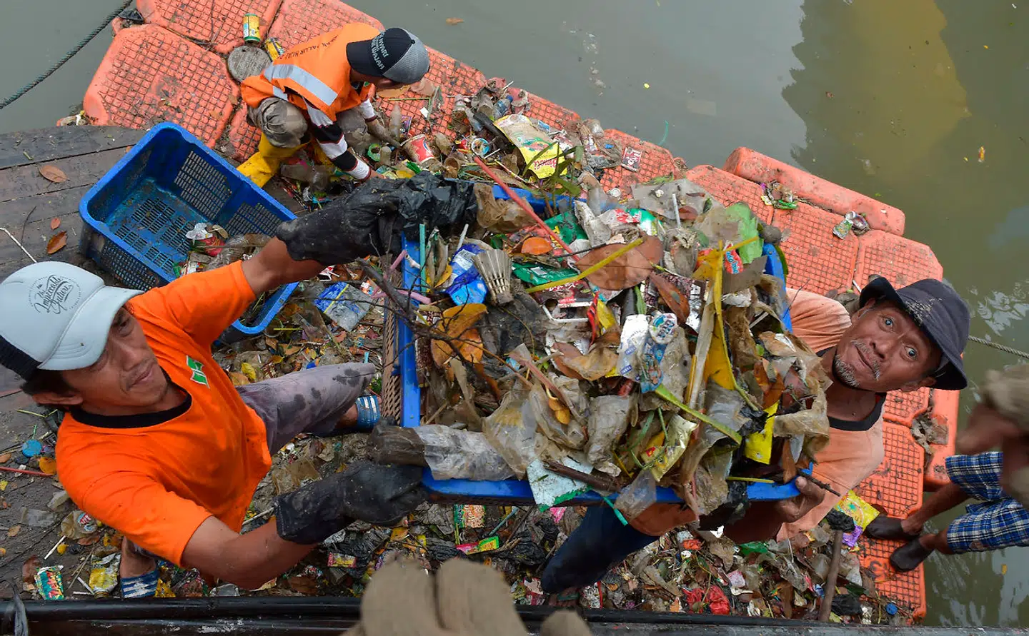 Arbejdere igang med at fjerne affald fra Ciliwung-floden i Jakarta.