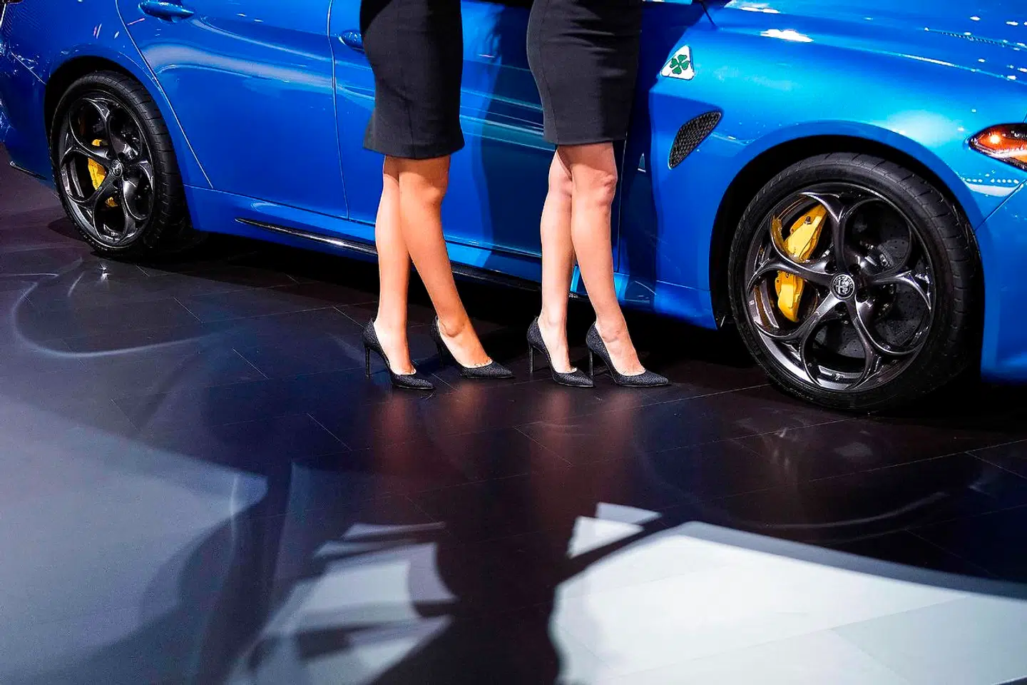 Én Alfa Romeo Giulia og to lårkorte bil-piger.