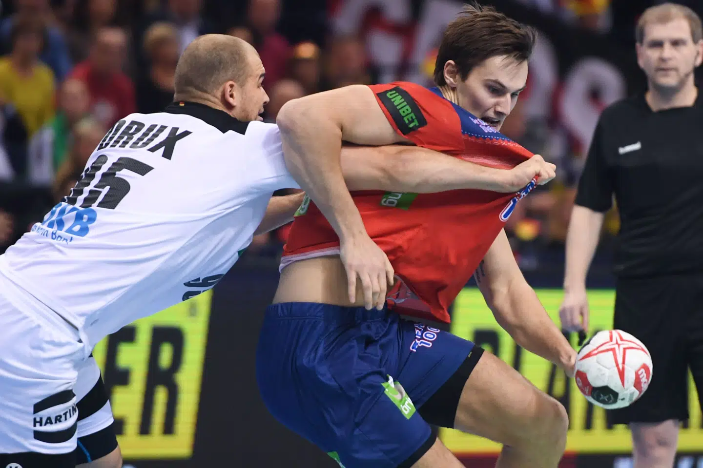 Norges bagspiller Magnus Rød blev revet i trøjen af tyske Paul Drux i fredagens semifinale i Hamburg. Norge endte med at vinde kampen. Patrik Stollarz/Ritzau Scanpix
