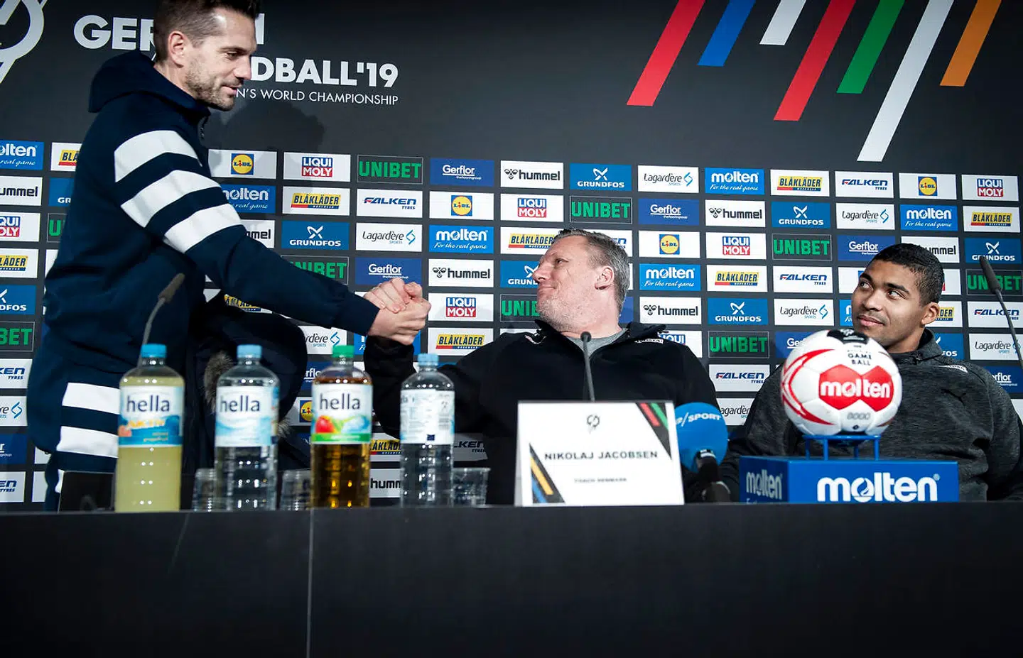 Landstræner Nikolaj Jacobsen og Mads Mensah hilser på Frankrigs ass. træner Guillaume Gille.