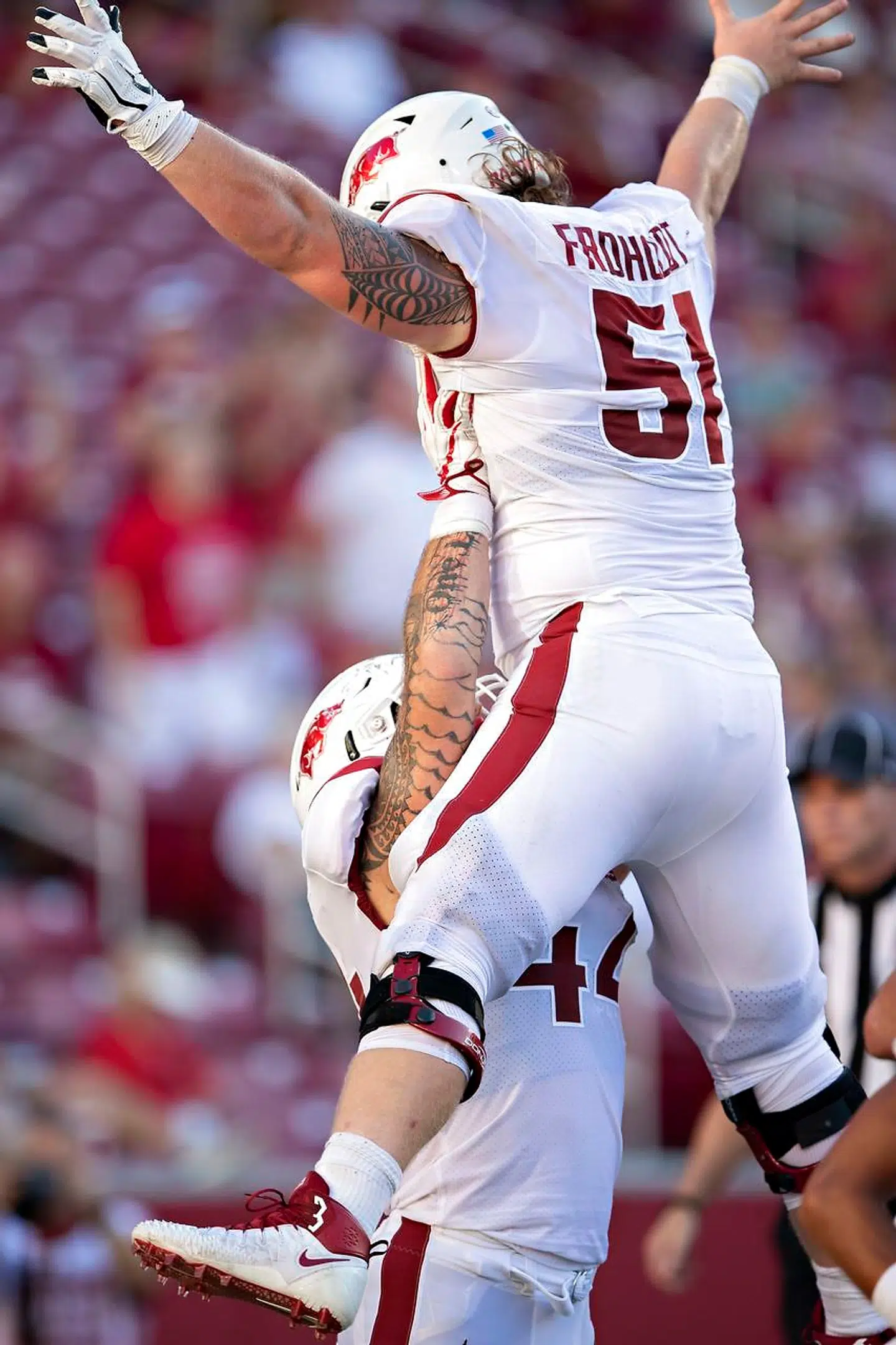 Hjalte Froholdt (med nummer 51) jubler med holdkammeraten Austin Cantrell over et touchdown til Arkansas Razorbacks.