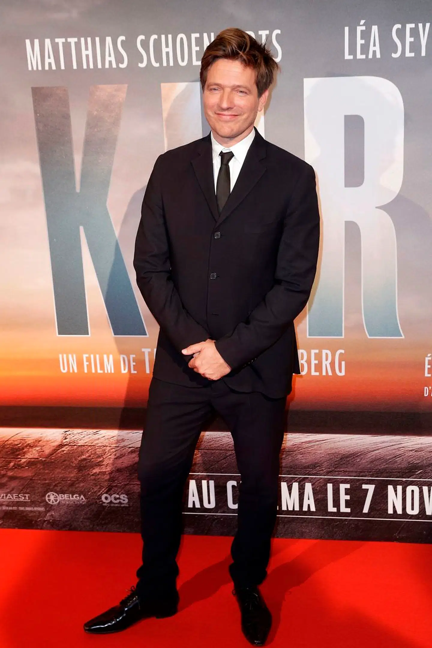 Thomas Vinterberg poserer foran Kursk-filmplakaten.