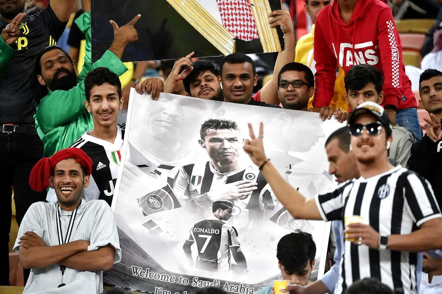 Juventus fans carry a poster of Juventus' Portuguese forward Cristiano Ronaldo during the Supercoppa Italiana final between Juventus and AC Milan at the King Abdullah Sports City Stadium in Jeddah on January 16, 2019. (Photo by Fayez Nureldine / AFP)