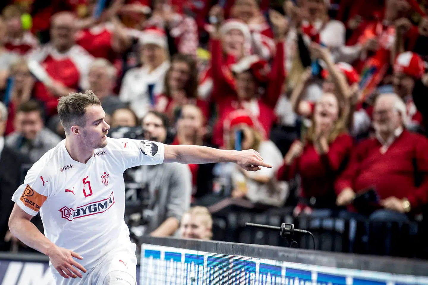 Casper U. Mortensen peger ud på et banner med sig selv.