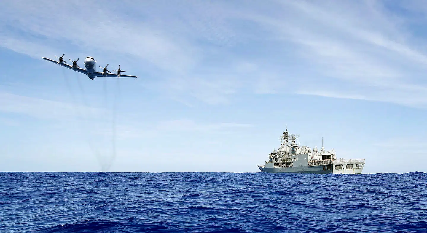 En Royal Australian Air Force AP-3C Orion flyver over HMAS Toowoomba under eftersøgningen af MH370.