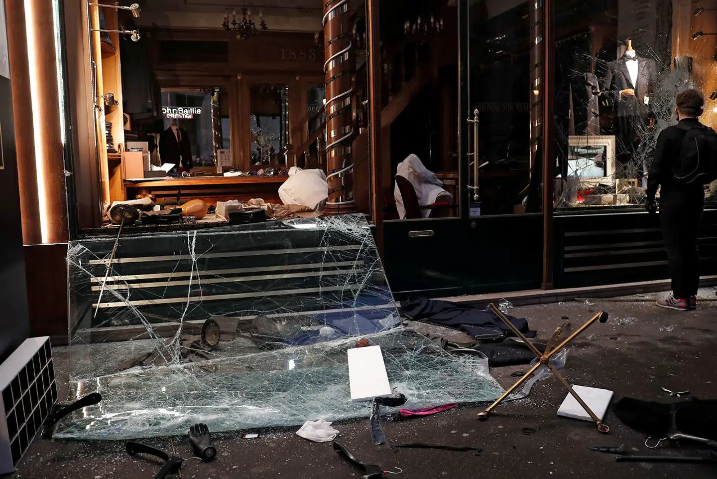 A man stops in front of a vandalized tailor's shop during a demonstration by the "yellow vests" movement in Paris, France, December 8, 2018. REUTERS/Benoit Tessier