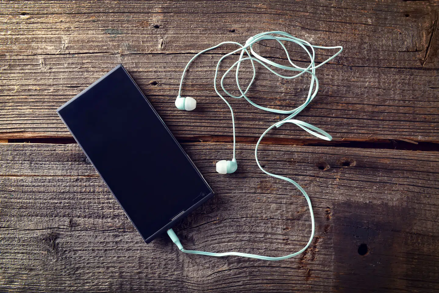 Mobiltelefon med høretelefoner (Arkivfoto).