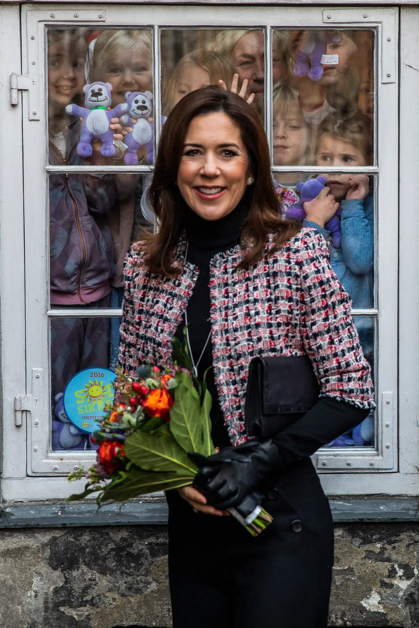 Kronprinsesse Mary blev budt velkommen af en gruppe børn, som stod i vinduet i deres institution i nogle tilstødende lokaler.