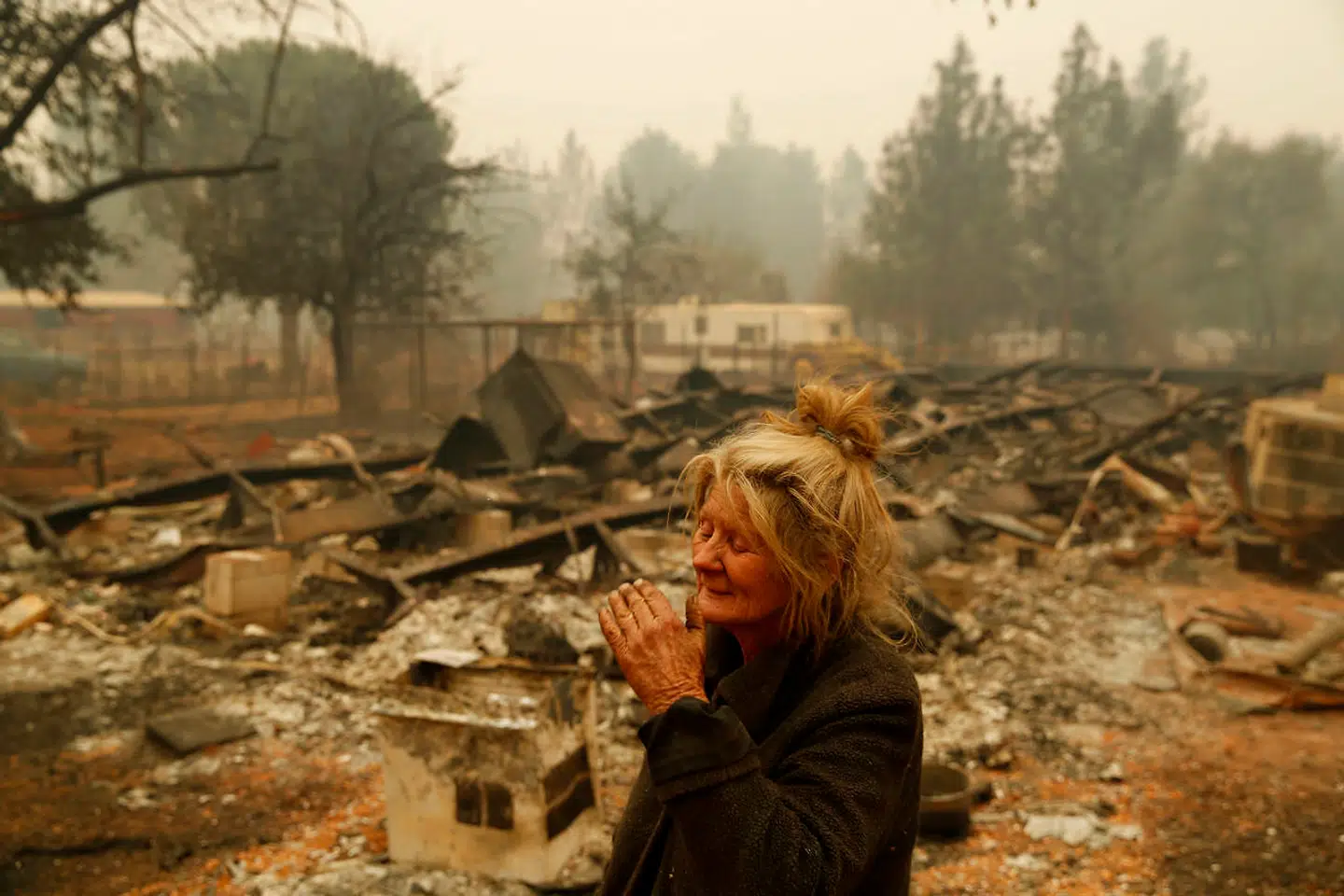Cathy Fallon er en af de mange beboere, der har mistet sit hjem til flammerne. Her ses hun ved ruinerne. De 14 heste, hun havde på ejendomme, overlevede dog alle.