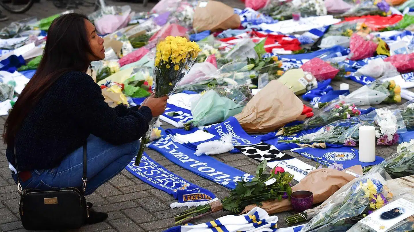 En kvinde lægger blomster efter en helikopter i går styrtede ned og brød i brand. (Photo by Ben STANSALL / AFP)