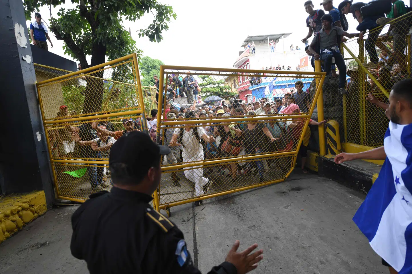 Honduranske migranter, der i samlet flok er vandret fra deres hjemland og til grænsen mellem Guatemala og Mexico, er fredag aften dansk tid brudt igennem grænsehegnet. Deres mål er at nå til USA, hvor præsident Trump har truet med at indsætte soldater ved grænsen. Pedro Pardo/Ritzau Scanpix