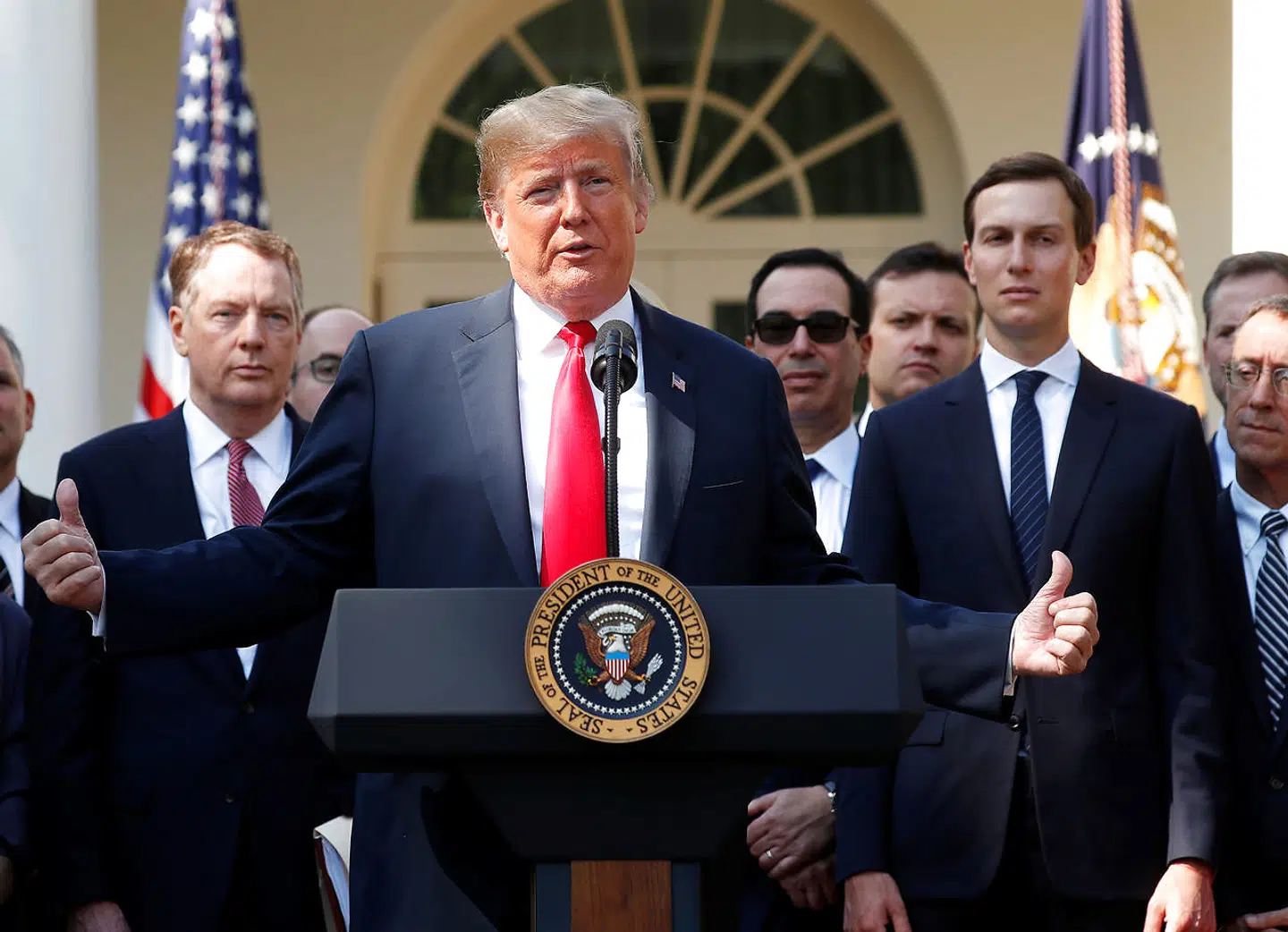Donald Trump under en tale foran Det Hvide Hus. Til højre står svigersønnen og rådgiveren Jared Kushner.
