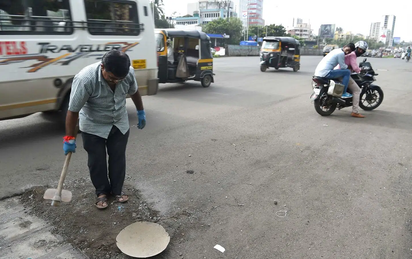 Taget den 29. august 2018 kan man på dette foto se Dadarao Bilhore fylde et hul op på en vej i Mumbai.