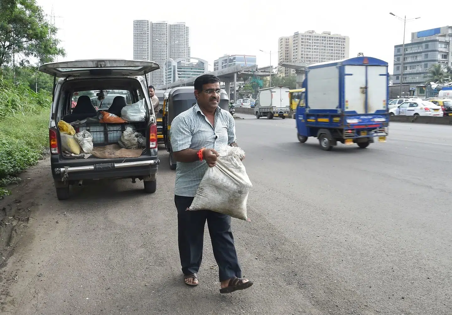 Her kommer forretningsmanden Dadarao Bilhore med en sæk fyldt med materialer, til at fylde huller i vejen op med.