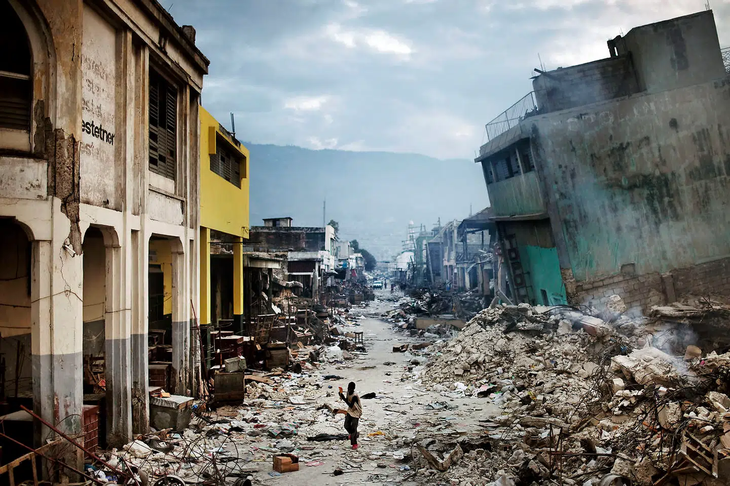 På det omtalte billede fra jordskælvet i Haiti flygter en ung haitianer fra urolighederne i downtown Port au Prince.