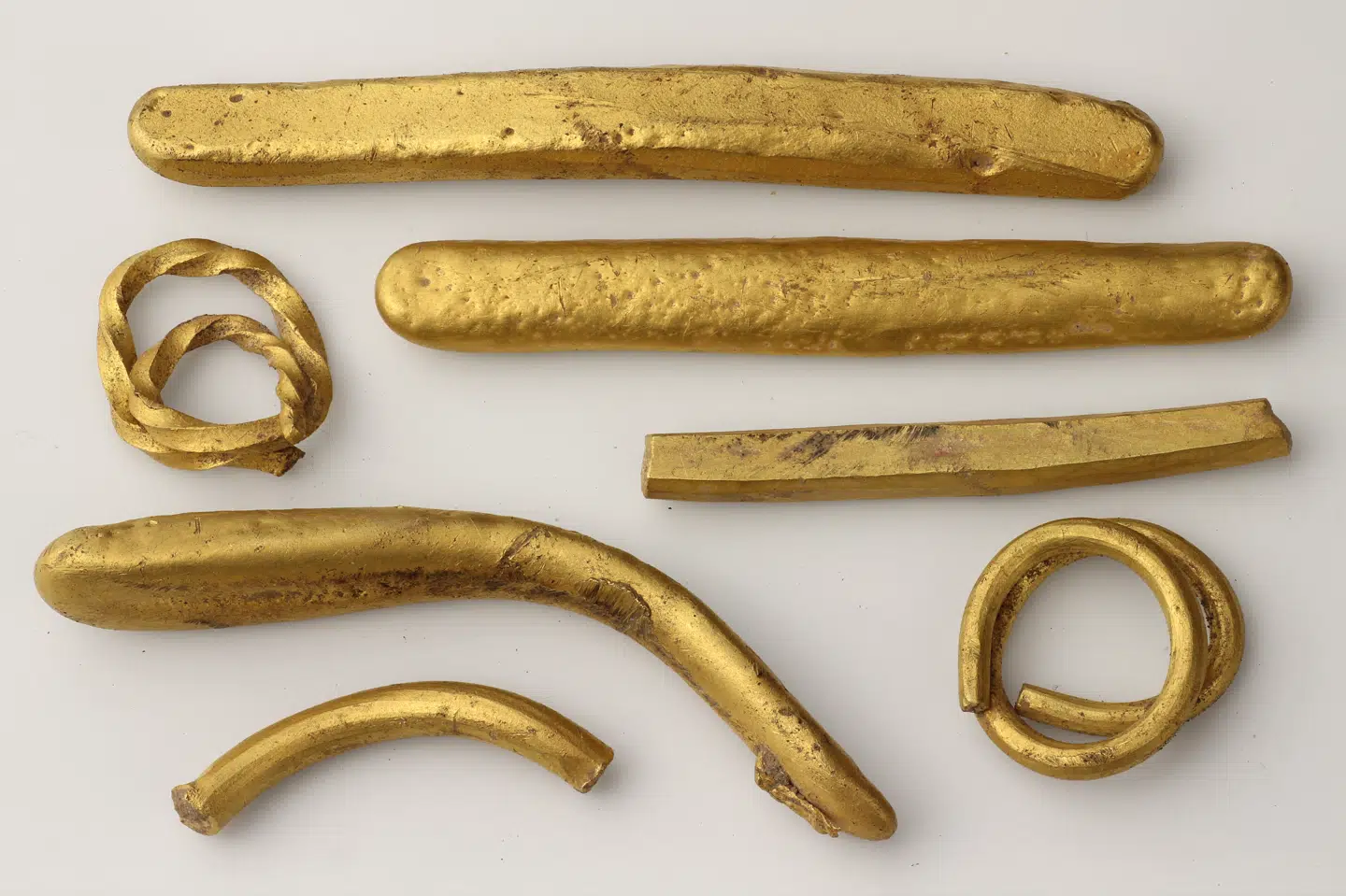 Guldskatten fundet ved Jyderup består af guldbarrer og guldringe af oprullet tråd.