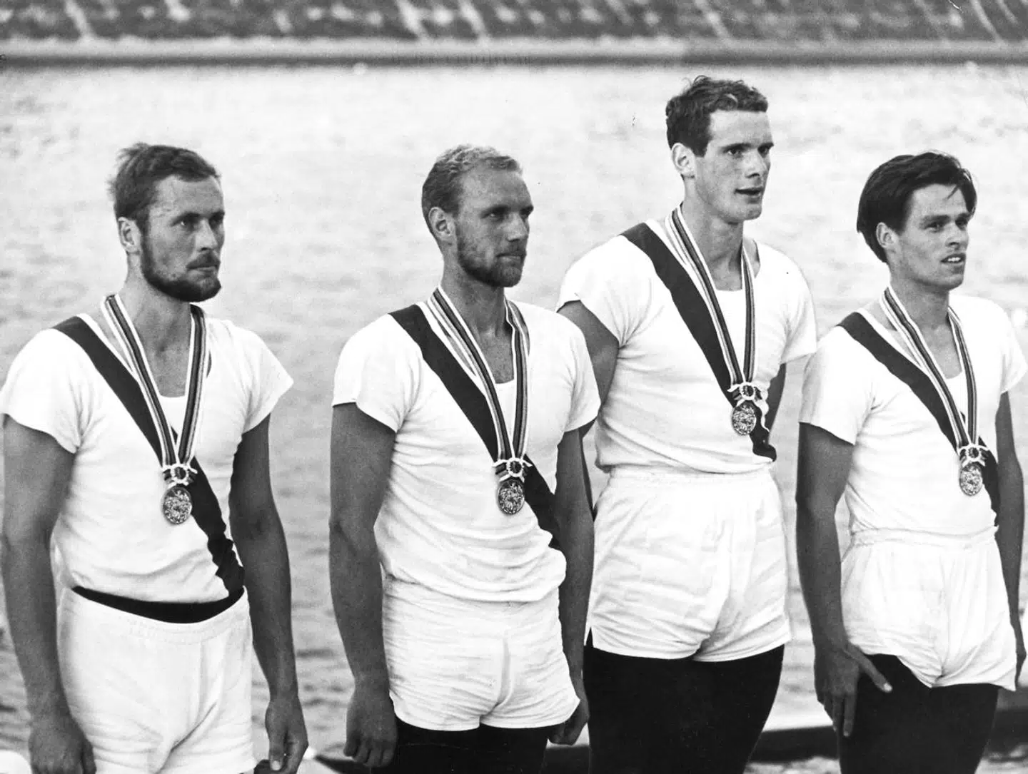 OL i Tokyo 1964. Roning.De fire guldvindere fra KVIK står ret, mens den danske nationalsang spilles. Fra venstre John Ørsted, Erik Petersen, Kurt Helmuth og Bjørn Hasløv.; Olympic games in Tokyo 1964. Four Gold medal rowers from KVIK rowing club standing at attention while the Danish national hymn is played. They are from the left: John Oersted ( Ørsted) , Erik Petersen, Kurt Helmuth og Bjoern Hasloev ( Bjørn Hasløv).;