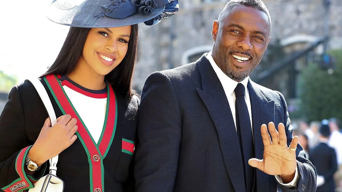 Her ses Idris Elba med sin forlovede, Sabrina Dhowre, ved prins Harry og Meghan Markles bryllup i maj.