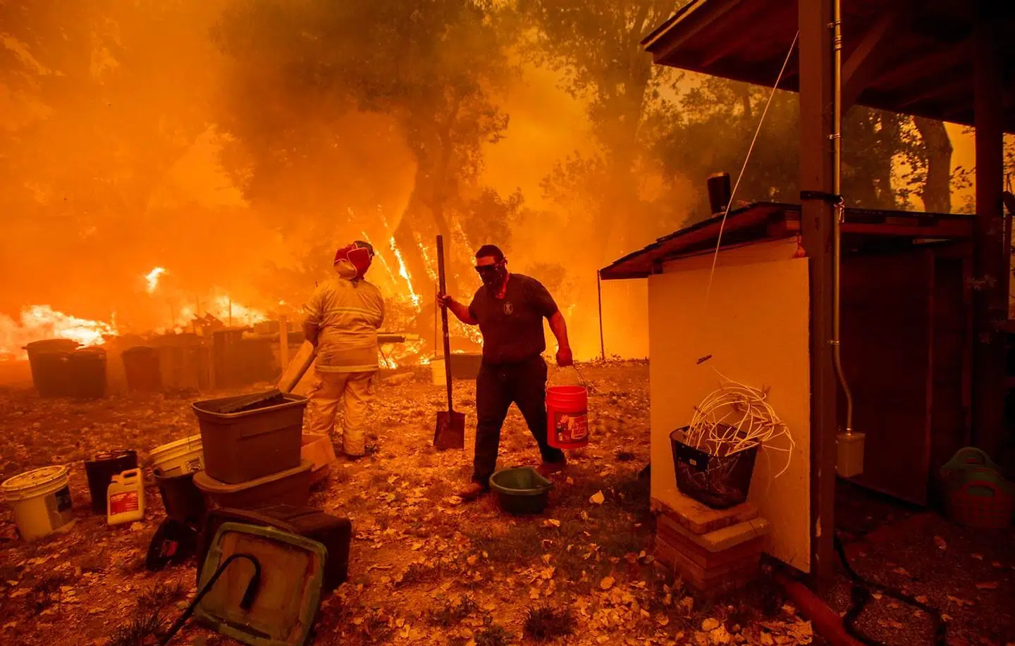 En brandmand forsøger sammen med gårdejeren at holde ilden på afstand ved Clearlake Oaks i Californien. Naturbrandene hærger voldsomt i den nordlige del af staten. AFP PHOTO / NOAH BERGER