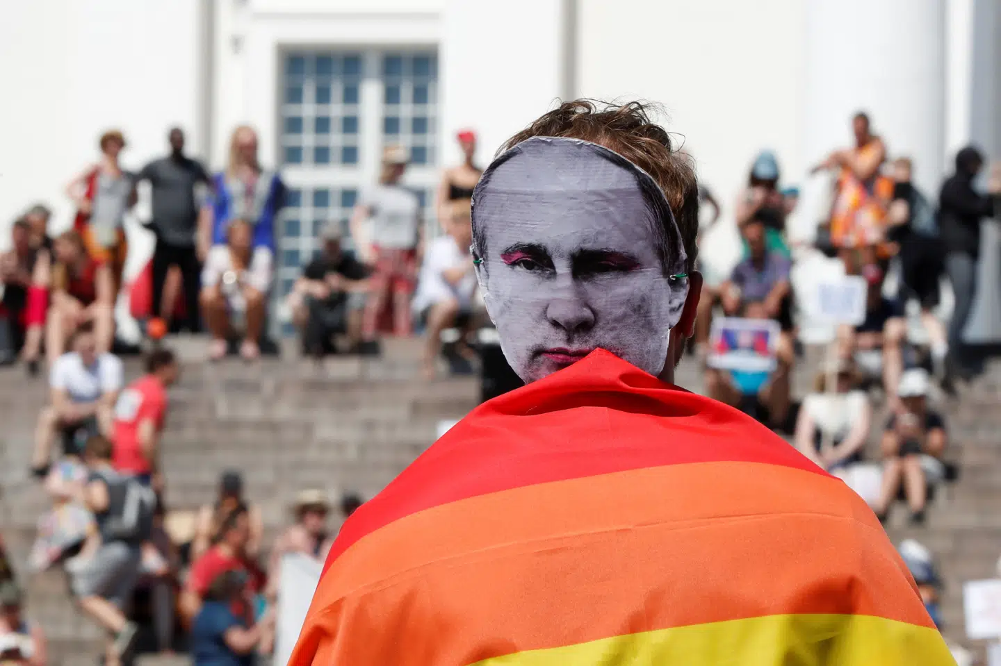 En person har en Putin-maske på, mens demonstranter protesterer i Helsinki forud for mødet mellem Ruslands og USA's præsident. Grigory Dukor/Reuters