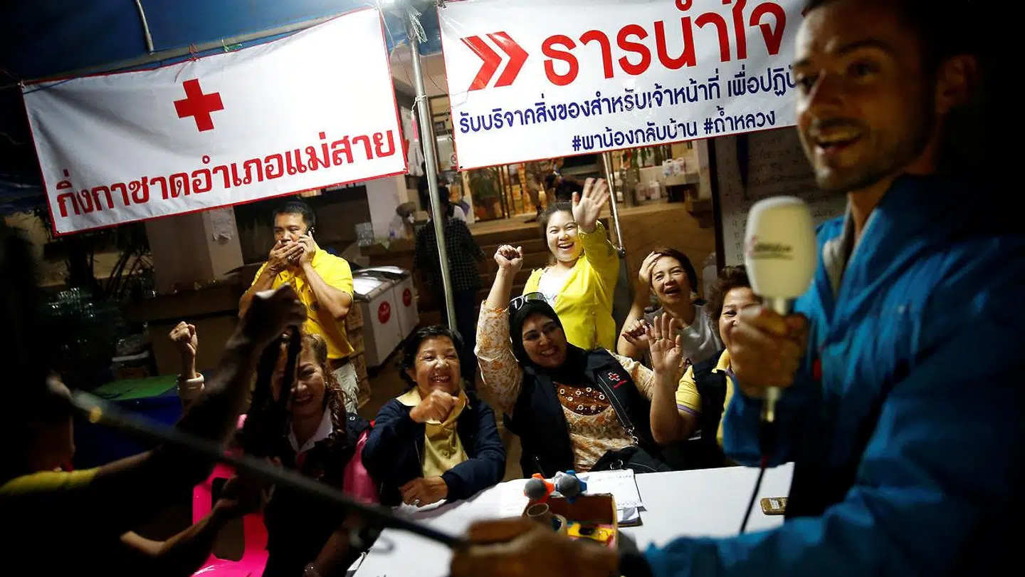 Frivillige fejrer, at alle drenge og deres træner er ude i sikkerhed. Redningsaktionen forløb over tre dage.