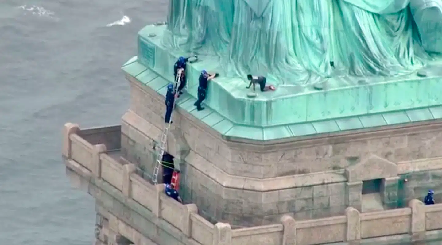 This still image taken from video Courtesy of PIX11 News in New York, shows police talking to a woman who climbed to the base of the Statue of Liberty in New York on July 4, 2018. According to media reports, Liberty Island has been evacuated and ferries to the site have been halted, while law enforcement attempt to get the woman down from the statue. / AFP PHOTO / PIX11 News / HO / RESTRICTED TO EDITORIAL USE - MANDATORY CREDIT "AFP PHOTO / Courtesy of PIX11 News" - NO MARKETING NO ADVERTISING CAMPAIGNS - DISTRIBUTED AS A SERVICE TO CLIENTS