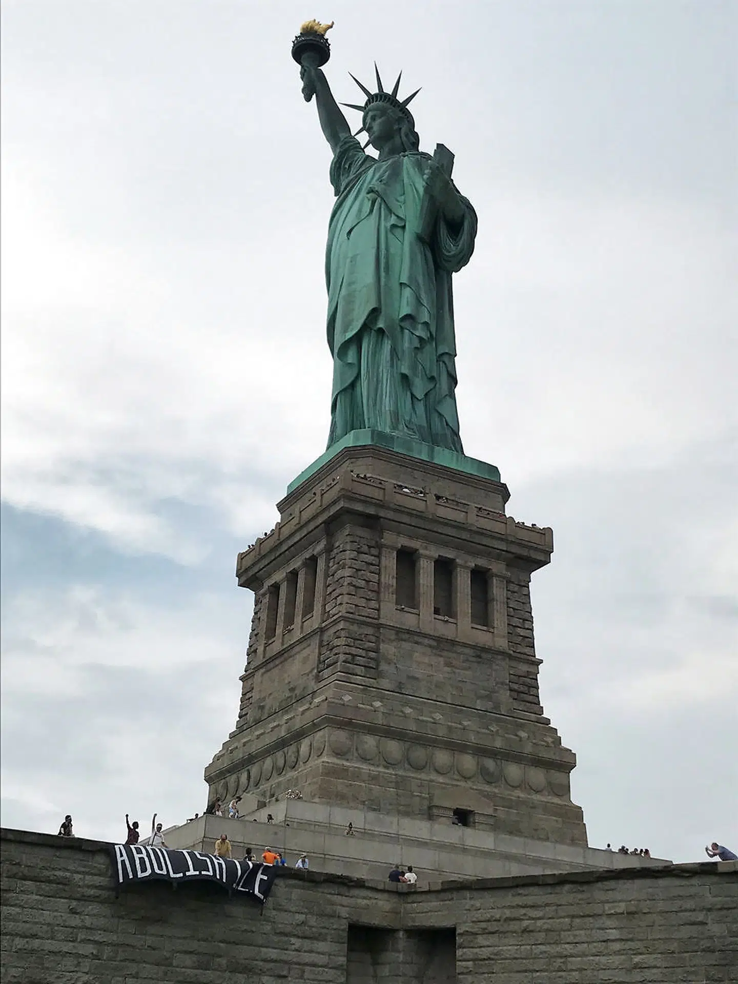 The group Rise and Resist stage a protest at the Statue of Liberty in New York, U.S. July 4, 2018 in this picture obtained from social media. Rise and Resist/via REUTERS ATTENTION EDITORS - THIS IMAGE HAS BEEN SUPPLIED BY A THIRD PARTY. MANDATORY CREDIT.NO RESALES.NO ARCHIVES.