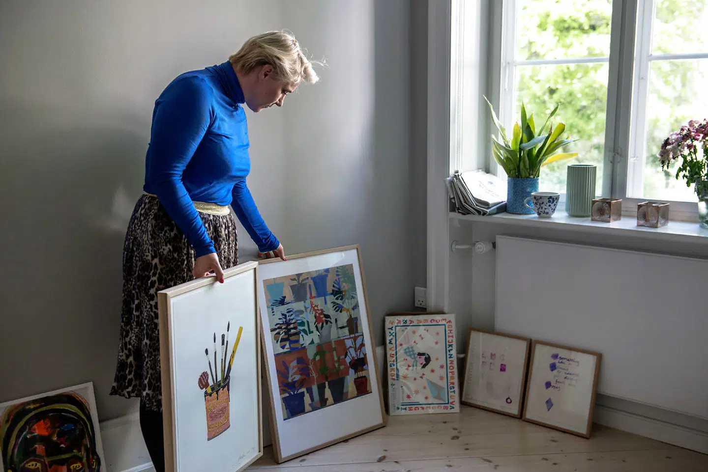 Mette Helena i gang med at indrette det nye beboerrum. Hun elsker kunst, og derfor bliver der hængt mange billeder på væggene.