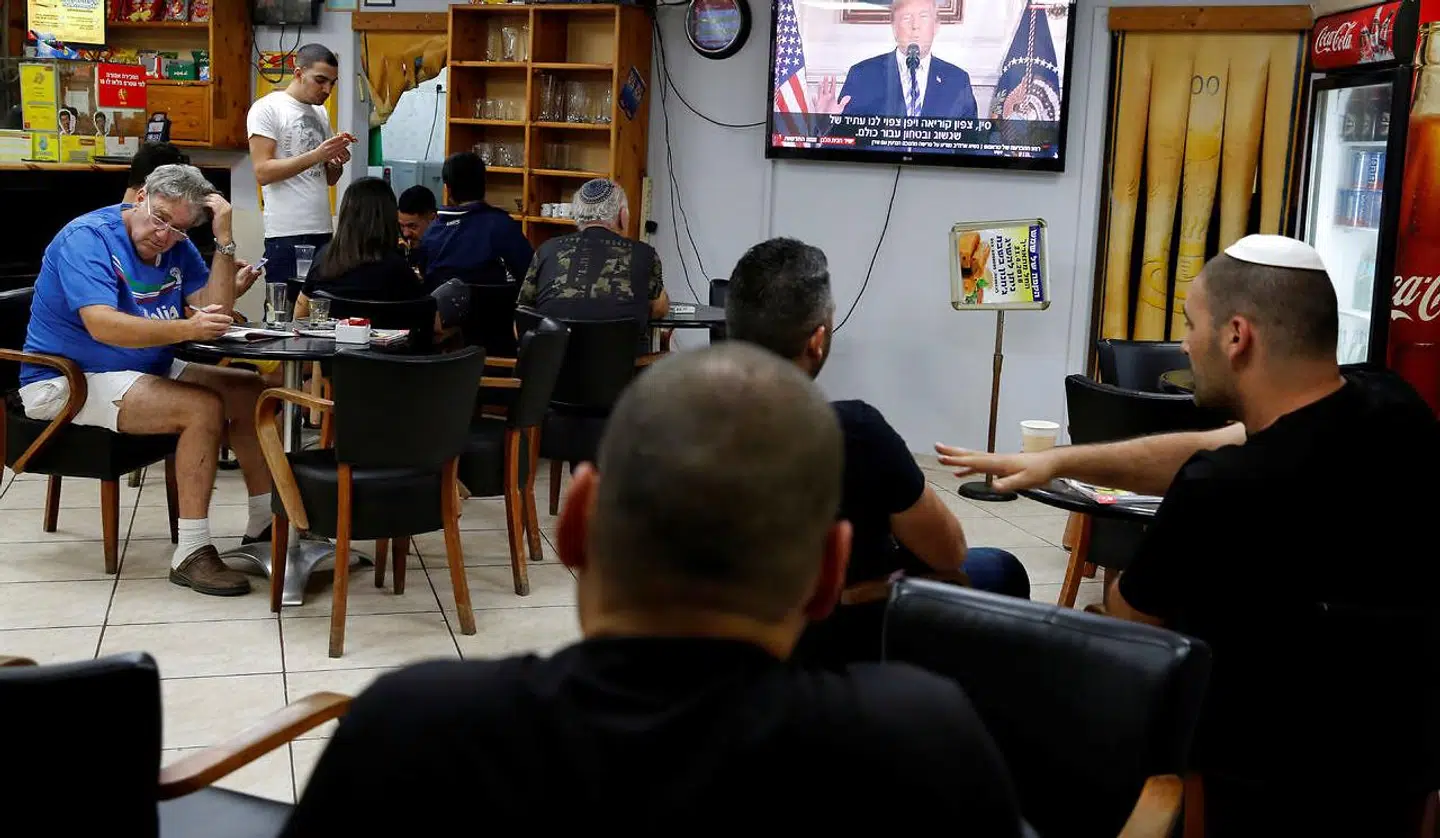 Israelere i en café følger Trumps tale på tv. Ashkelon i Israel, tirsdag aften. Den 8. maj.