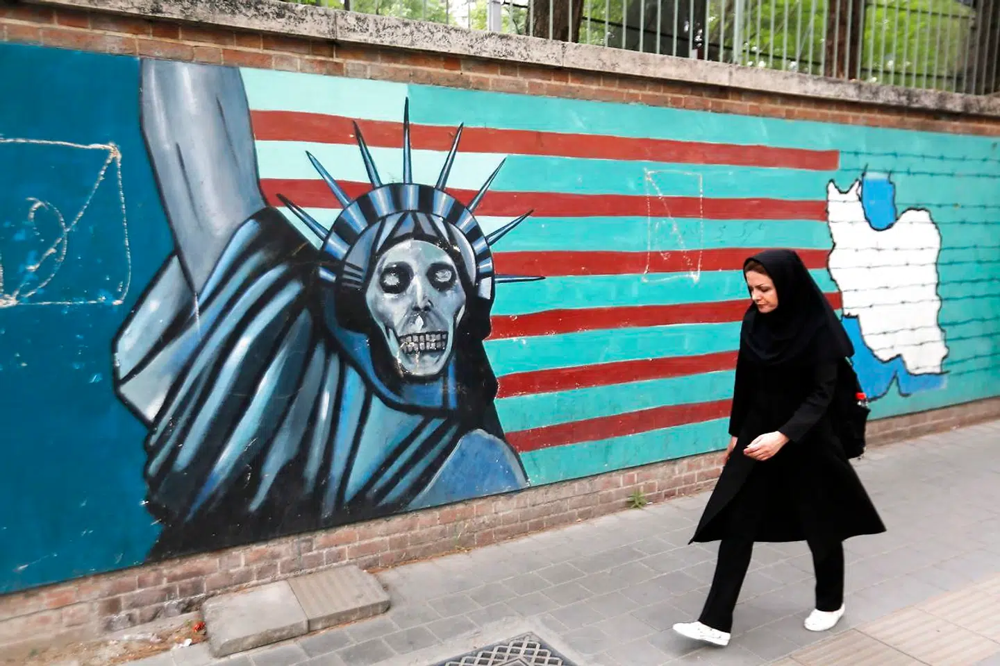 En iransk kvinde går forbi et vægmaleri i Teheran. Billedet her er fra den 8. maj.