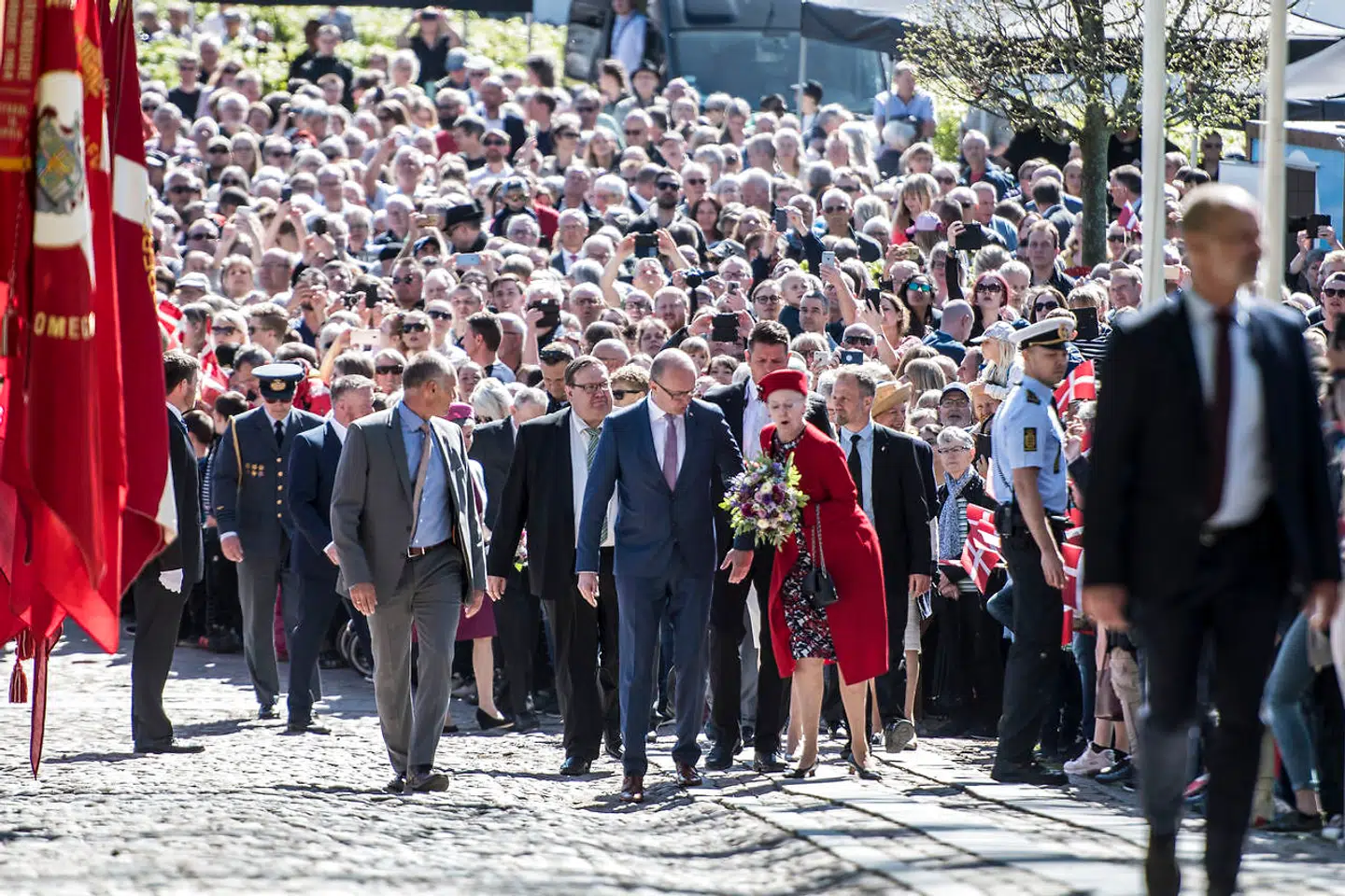 Imponerende mange var mødt op for at byde dronning Margrethe velkommen. Her er hun dog tæt på at snuble på brostenene.
